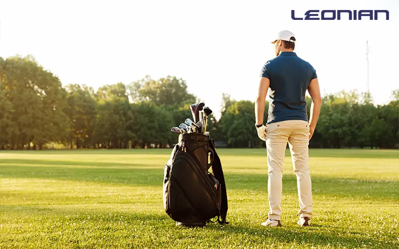Golfer with a cart bag on a sunny golf course.