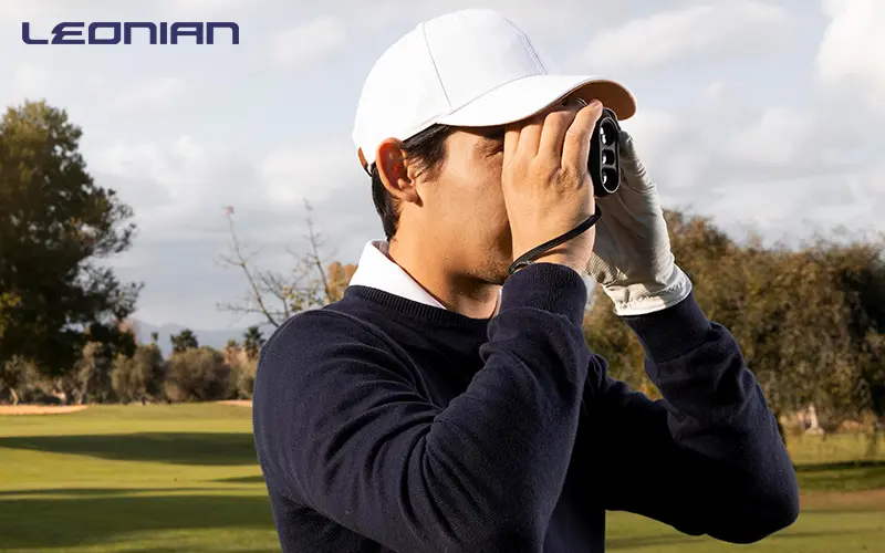 Golfer using a rangefinder to determine the distance.